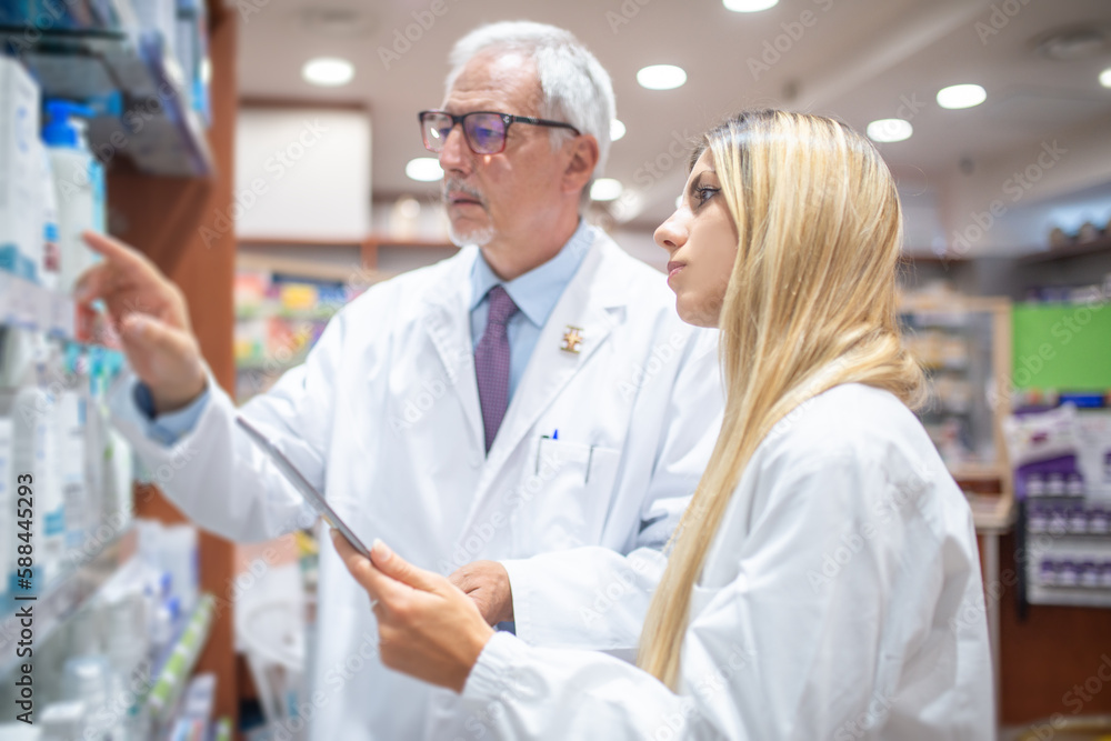 Pharmacists checking their inventory in their pharmacy Pharmacists checking their inventory in their pharmacy