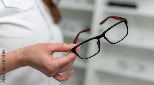 Stylish eyeglasses holding in hands. Woman hands holding modern eyewear.