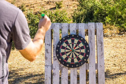 Young man playing dart target at outdoor. Having fun concept.