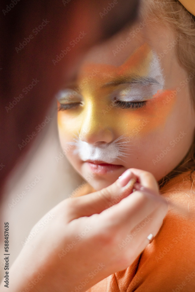 childrens makeup face paint drawings Girls face painting. Little girl having face painted on birthday party. closed eyes. High quality photo