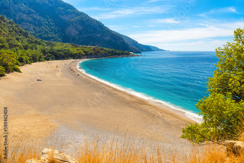 Fototapeta Naklejka Na Ścianę i Meble -  Beautiful Kidrak beach with sandy beach and blue water near Oludeniz town on the coast of Mugla region in Turkey