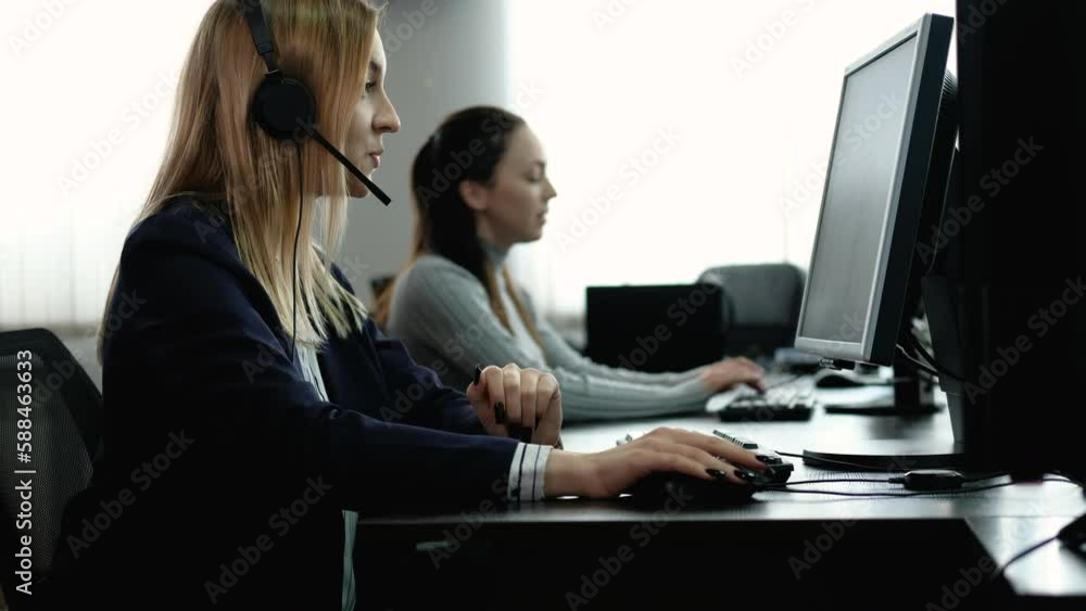 Female consultant works in an office. operator of communication center in headphones communicates with client and helps to solve problem. Technical assistance around clock. Help online Female consultant works in an office. operator of communication center in headphones communicates with client and helps to solve problem. Technical assistance around clock. Help online