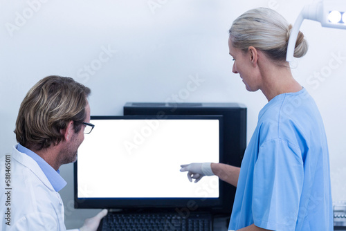 Dentist and dental assistant discussing a x-ray on the monitor