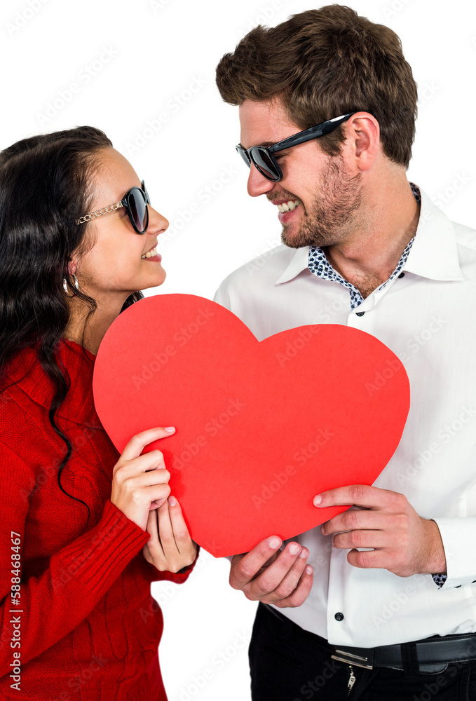 Smiling couple with sunglasses holding paper heart
