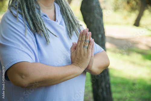 Mindful senior woman close up with dreadlocks meditating on nature - wellness and yoga practice