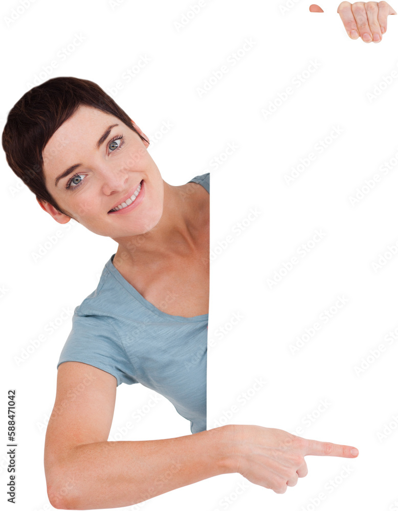 Smiling brunette pointing at a blank panel Smiling brunette pointing at a blank panel