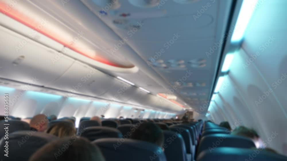 Airplane interior with people sitting during the flight. Travel concept. Blurred Airplane interior with people sitting during the flight. Travel concept. Blurred