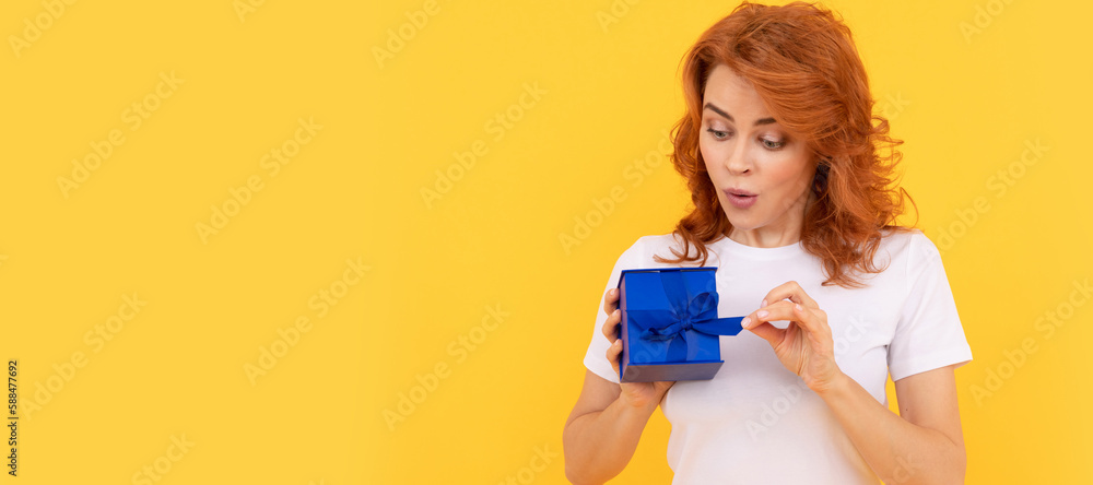shocked lady with purchase box on yellow background, boxing day. Woman isolated face portrait, banner with mock up copy space. shocked lady with purchase box on yellow background, boxing day. Woman isolated face portrait, banner with mock up copy space.