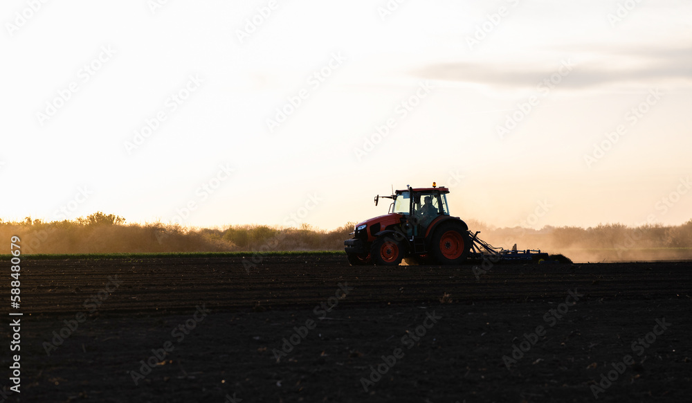 Fototapeta premium Farmer preparing his field in a tractor