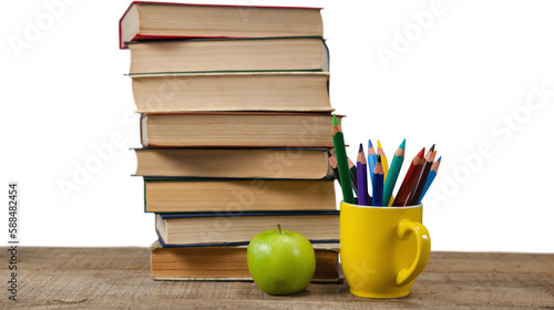Stack of books by colored pencils in mug and apple on table