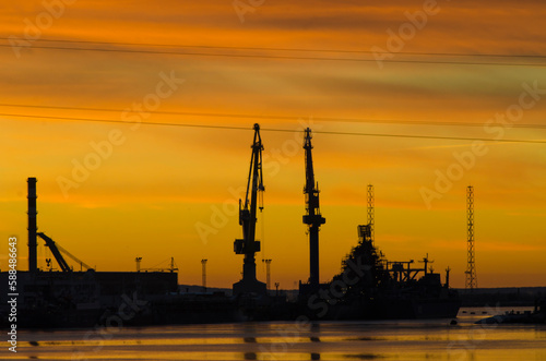 Big plant. Port cranes. Shipyard. Yellow sunset. industrial landscape