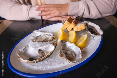 open oysters on a plate, on a dark surface