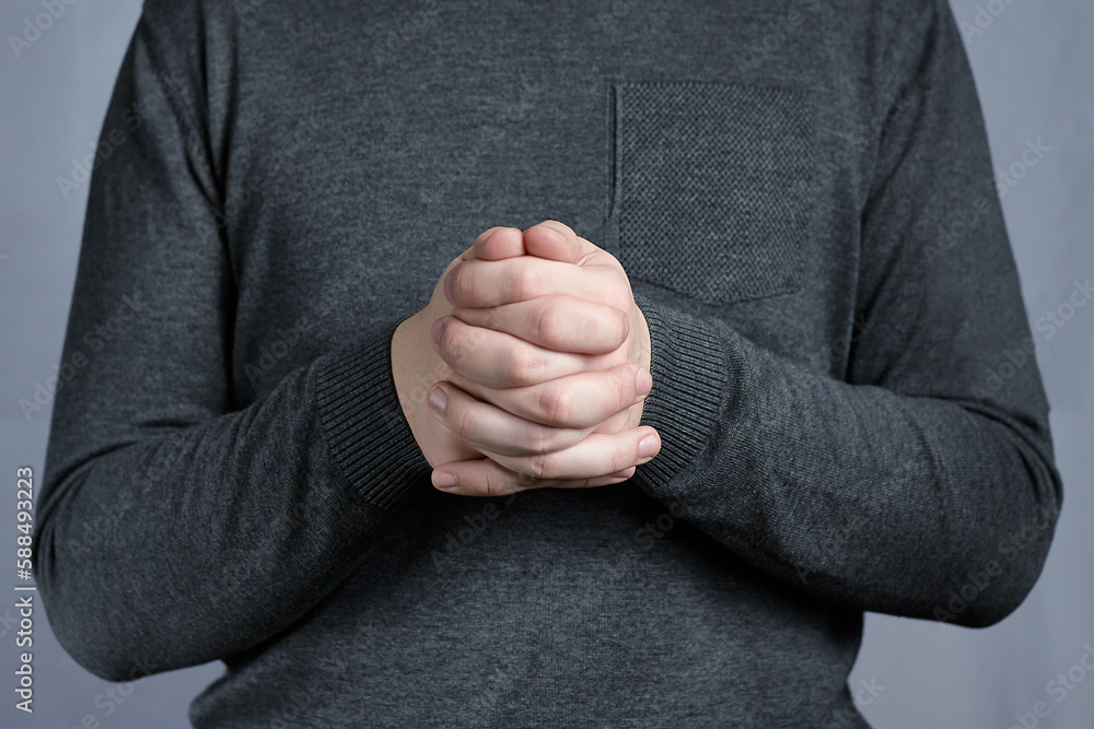 Fingers of two hands pressed tightly together. Sign of thoughtfulness