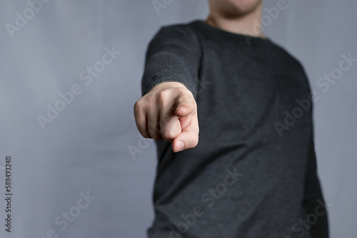 Fotografie Gesture pointing at you from the picture with a young man's index finger