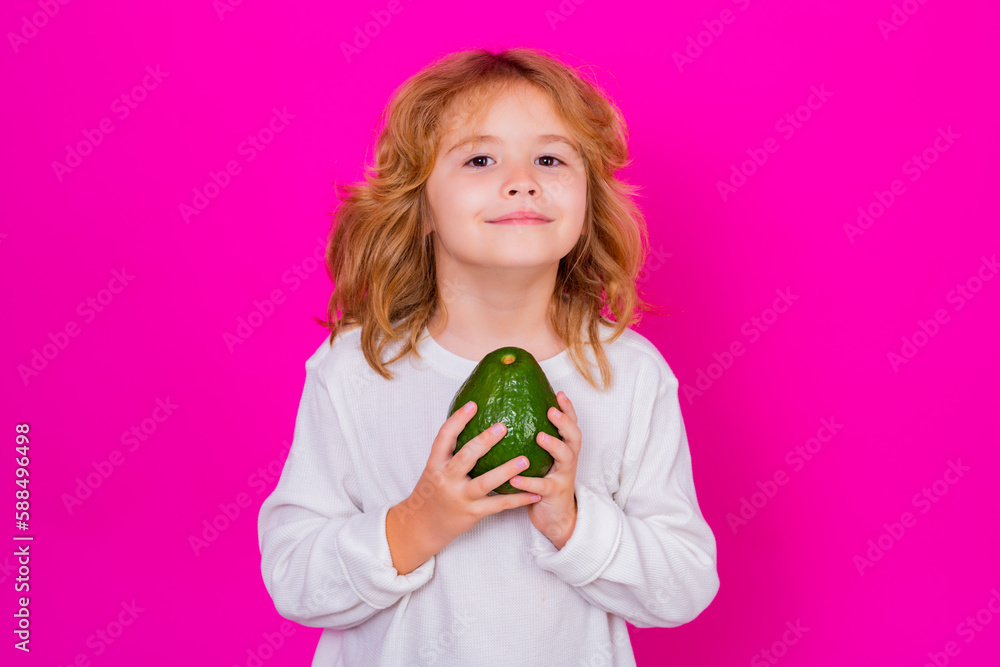 Avocado. Kid hold red avocado in studio. Studio portrait of cute child with avocado isolated on pink background. Avocado. Kid hold red avocado in studio. Studio portrait of cute child with avocado isolated on pink background.