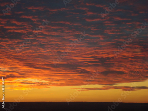 Epic colorful summer sunset landscape with dramatic clouds. Black horizon and scenerous view