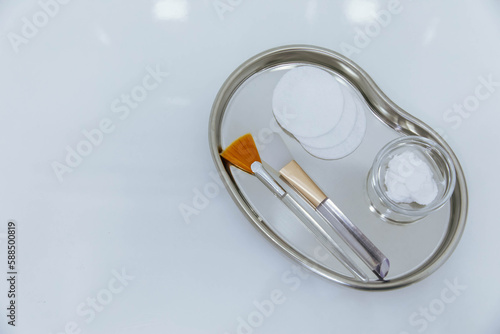 Brushes and cream on a metal tray, equipment for cosmetologist