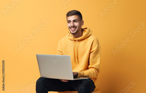 AI generated young happy handsome man looking at the camera using a laptop device , typing on the keyboard with one hand , isolated on a monocolor background