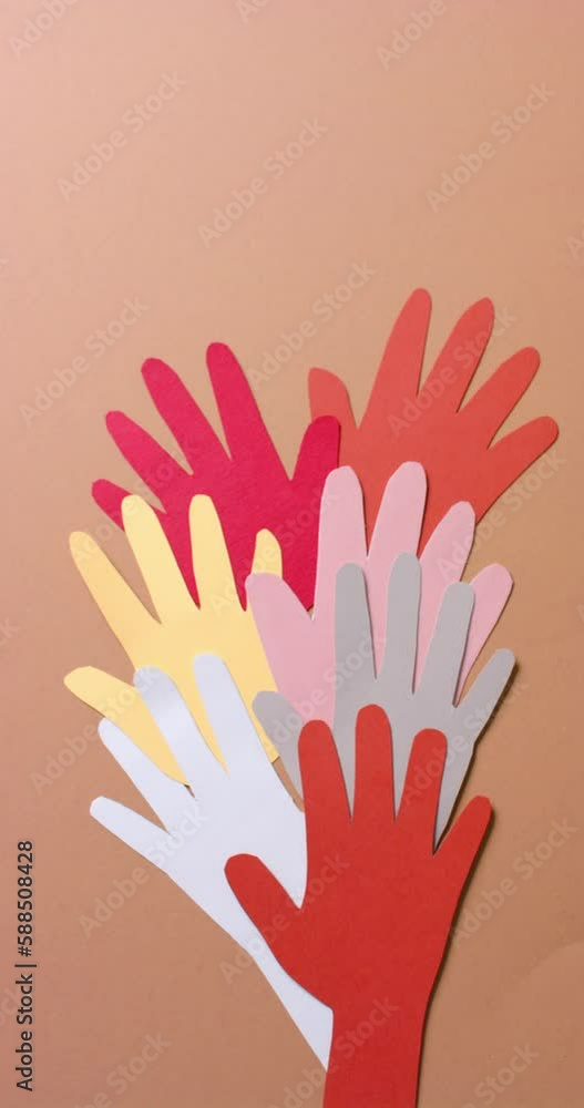 Vertical video of hands together made of colourful paper on brown background with copy space Vertical video of hands together made of colourful paper on brown background with copy space