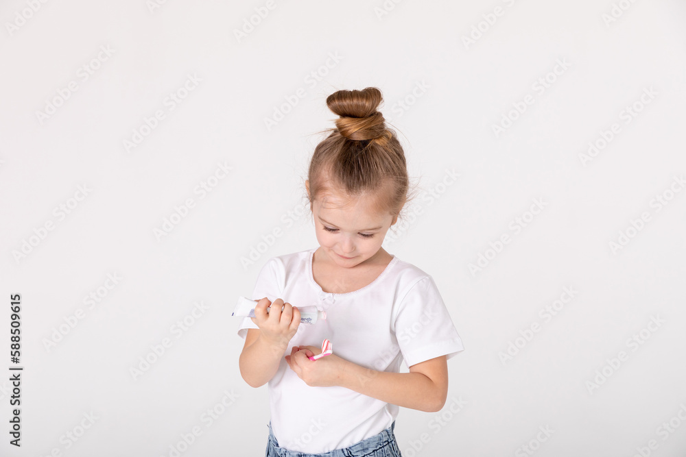Little cute child girl brushing her teeth on white background. Space for text. Healthy teeth. Little cute child girl brushing her teeth on white background. Space for text. Healthy teeth.