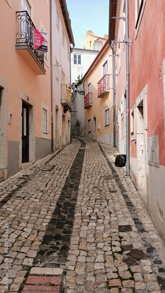 Obraz premium A narrow alley in Lisbon where people walk