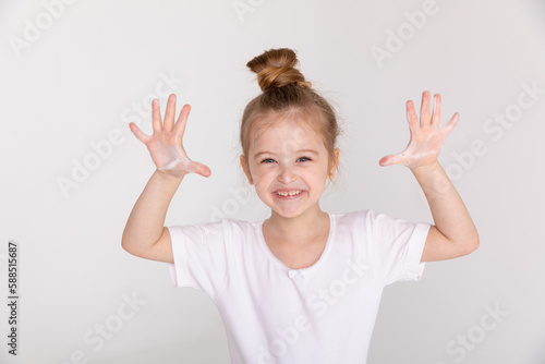 Wallpaper Mural Happy little girl in white T-shirt washes her hair in the bathroom and shows soap palms foam Torontodigital.ca