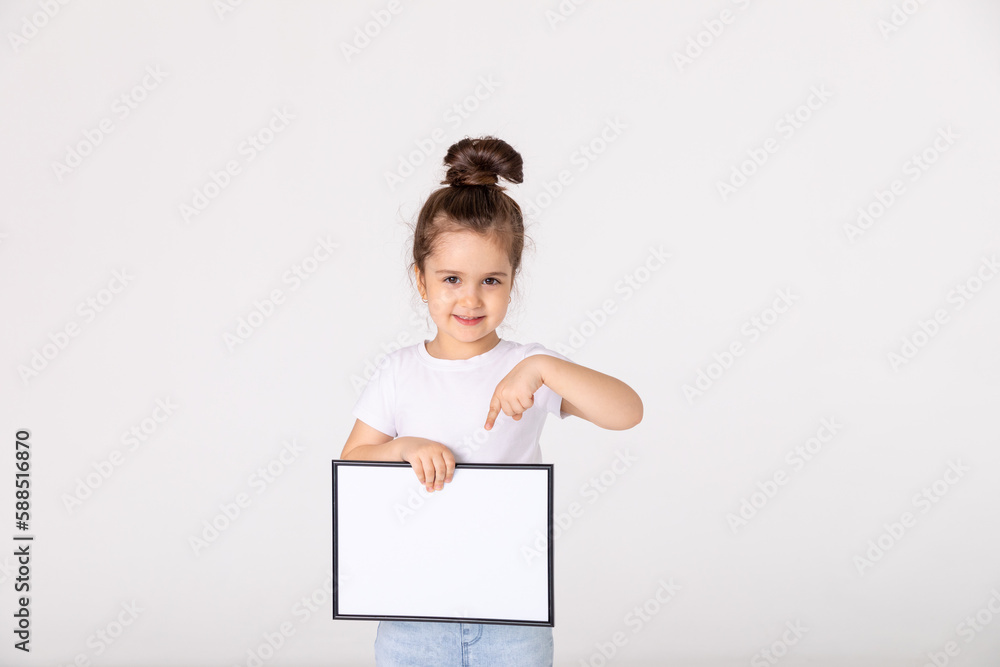 portrait of baby girl holding white drawing Board on white background, young girl is holding a drawing board in her hands. white isolated background portrait of baby girl holding white drawing Board on white background, young girl is holding a drawing board in her hands. white isolated background