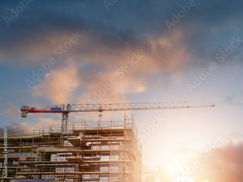 Obraz na plátne New building construction in scaffolding and tall crane