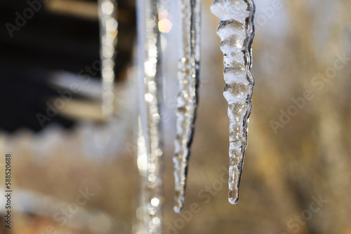 spring icicles hanging from a roof in sunny day