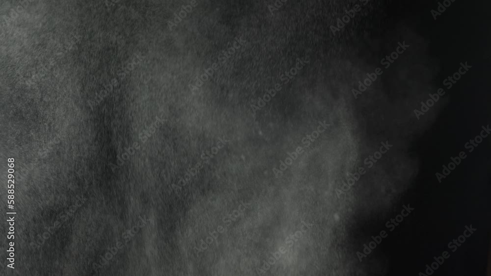 Throwing flour on a black background. White dust explosion effect. For different effects. Flour is falling everywhere. White dust on a black background Throwing flour on a black background. White dust explosion effect. For different effects. Flour is falling everywhere. White dust on a black background