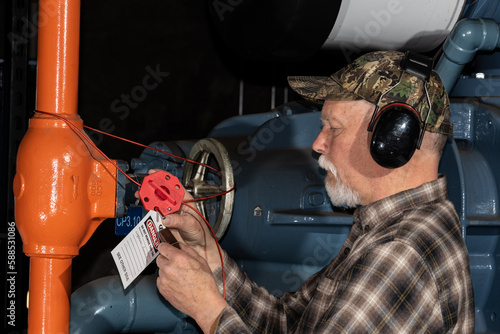 technician applying lockout on ammonia valve
