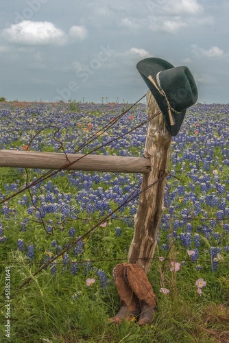 Hat and boots by a fence post