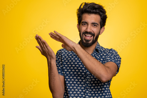 Young indian man showing wasting  throwing money around  more tips  big profit  winning lottery jackpot  successful shopping payment purchase  cashback. Hindu guy isolated on studio yellow background