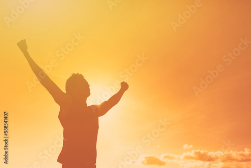 People power and strength. Silhouette of young man with fist up to the sky 