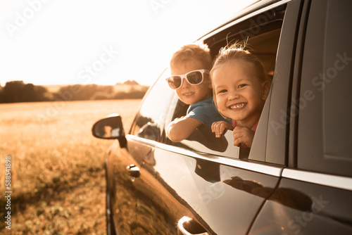 Portrait of happy little boy and girl in car. Family road trip,  summer holiday travel concept. 