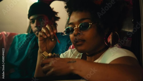 Stylish African American woman with ice cream in car.
