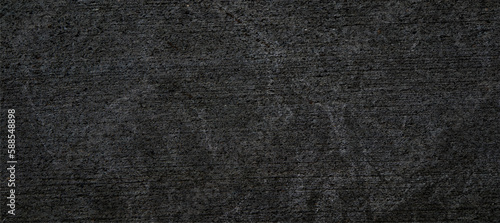 Black grunge textured concrete wall for backgrounds, banners and web elements. Dark crumpled rough surface.
