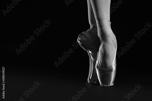 Ballerina in pointe shoes dancing, closeup with space for text. Black and white effect © New Africa