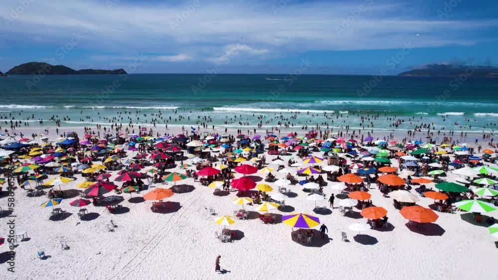 Vista do drone sobre a praia com dunas cheia de turistas e guarda-sol, mar limpo e areia branca na verão na cidade de Cabo Frio, Rio de Janeiro, Brasil Vista do drone sobre a praia com dunas cheia de turistas e guarda-sol, mar limpo e areia branca na verão na cidade de Cabo Frio, Rio de Janeiro, Brasil