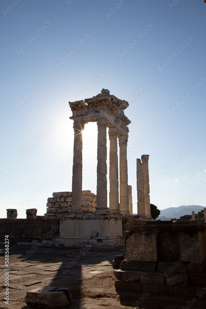 Ruins of the Temple of Trajan the ancient site of Pergamum (Pergamon). Izmir, Turkey. Ancient city columns with the sun in the background.