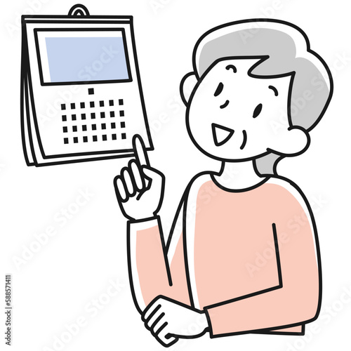 カレンダーを見て日にちを確認するシニア女性の上半身