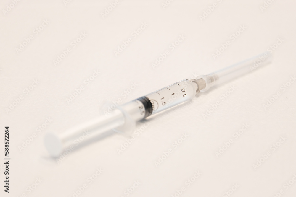 Close up needle syringe on white ground. Selective close of needle. Open space area. Close up needle syringe on white ground. Selective close of needle. Open space area.