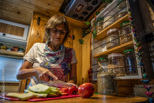 Senior woman prepares vegan food in the kitchen of a motorhome. photo