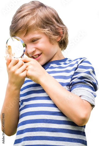 Young boy looking at leaf through magnifying glass