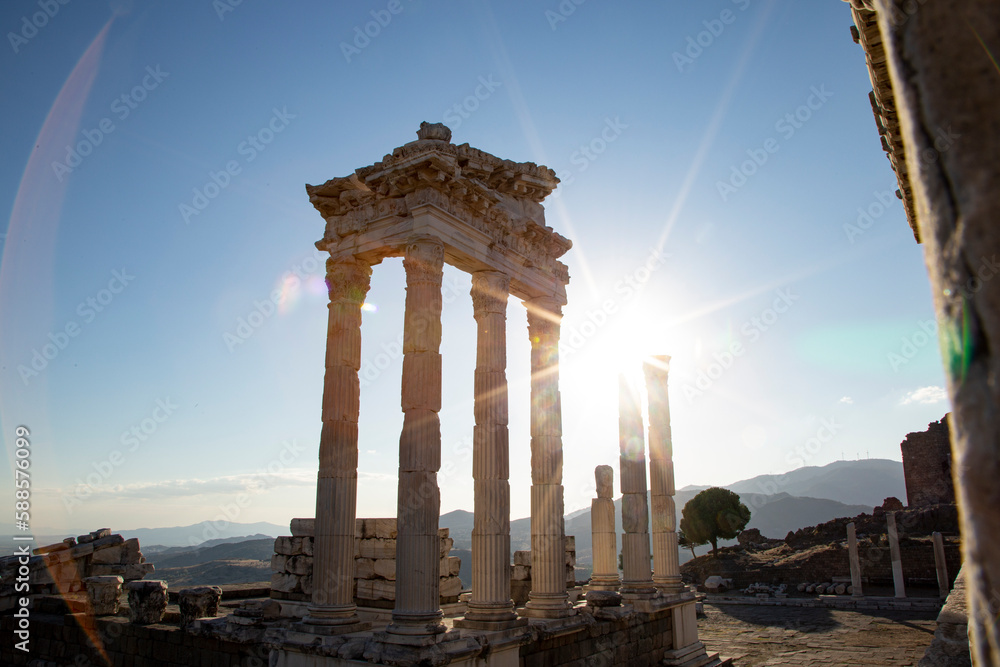Fototapeta premium Ruins of the Temple of Trajan the ancient site of Pergamum (Pergamon). Izmir, Turkey. Ancient city columns with the sun in the background.