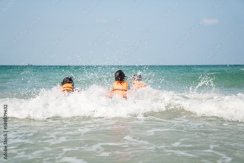 children playing water on beach in sea on summer holiday time on sunny sky background children playing water on beach in sea on summer holiday time on sunny sky background