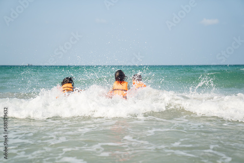 children playing water on beach in sea on summer holiday time on sunny sky background