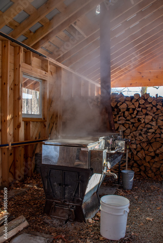 Boiling maple syrup over a wood fired boiler in a maple sugar shack in Ontario, Canada