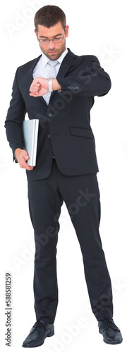 Serious businessman holding laptop checking time