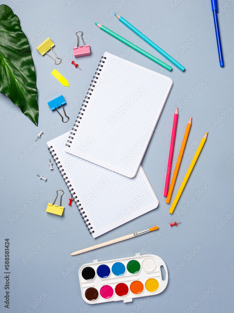 Flat lay office desk with a blank page of a notebook with a pen, pencils, watercolor and other stationery. Top view, flat lay. Flat lay office desk with a blank page of a notebook with a pen, pencils, watercolor and other stationery. Top view, flat lay.